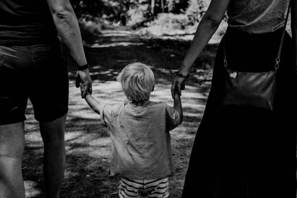 parents holding the hand of a child